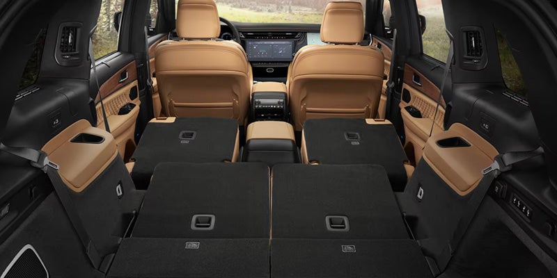 Jeep Grand Cherokee interior with folded rear seats showing expanded cargo space.