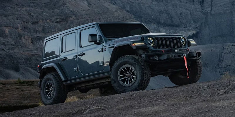 2026 Jeep Wrangler Rubicon SUV climbing rocky off-road terrain