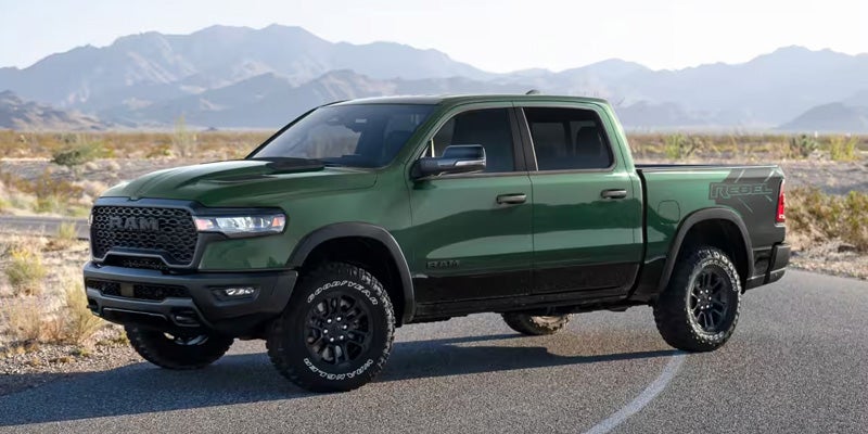 2026 Ram 1500 green pickup truck parked on scenic road