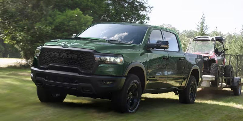 2026 Ram 1500 green pickup truck towing trailer outdoors
