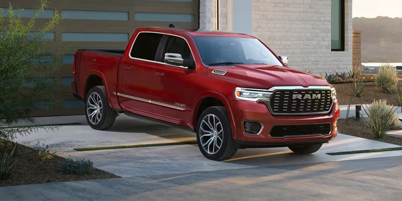 2026 Ram 1500 red pickup truck parked near modern building