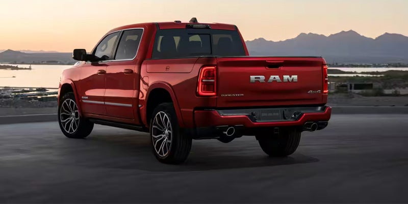 2026 Ram 1500 red pickup truck rear view on scenic road