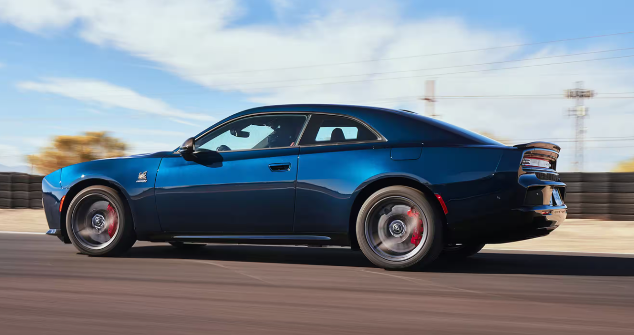 Blue 2026 Dodge Charger Daytona driving on a race track.